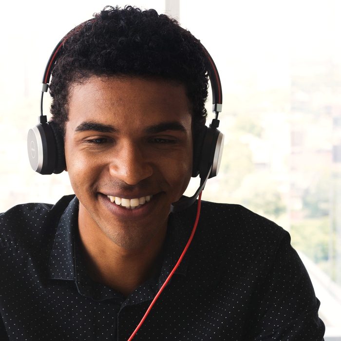 A young person smiling while working at a screen