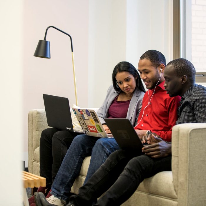 A group of young people working together on laptops
