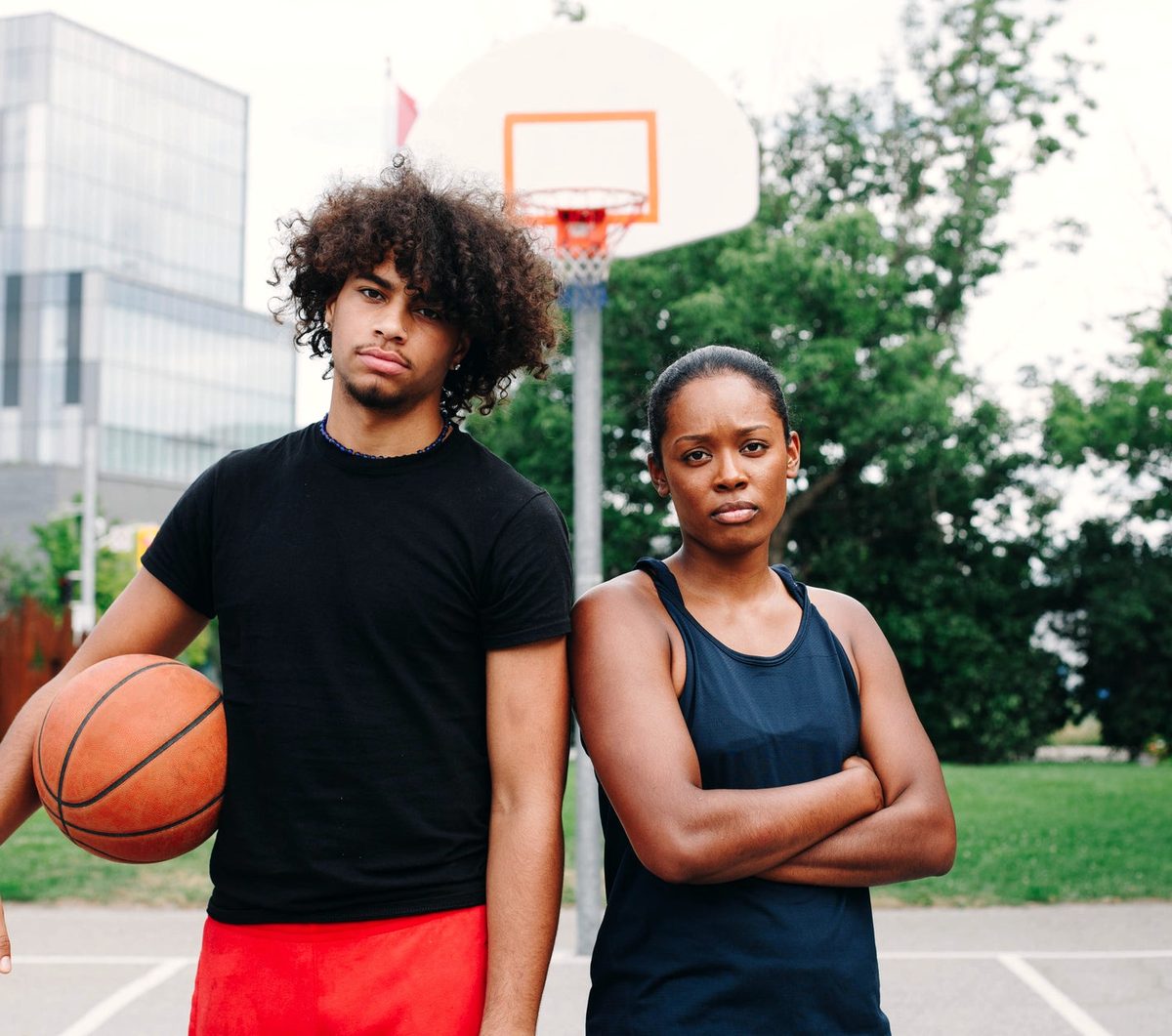 Two young people standing together on a basketball court