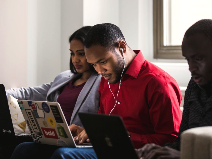 Volunteers gathered around laptops during a training session